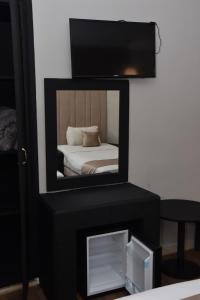 uno specchio su un supporto con un letto in una stanza di Cadé Hotel a Casablanca