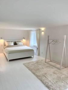 Dormitorio blanco con cama y mesa en Gîte de charme, en Anhée