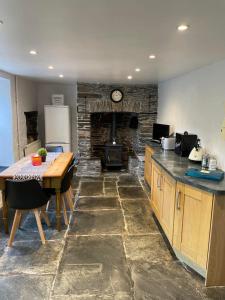 a kitchen with a table and a kitchen with a fireplace at Myrtle Cottage Boscastle in Boscastle