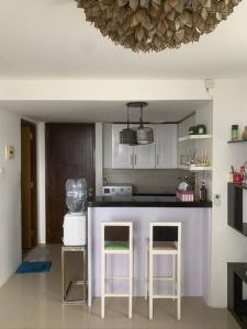 a kitchen with a purple counter and two stools at 2BR VIVO Apartement by MJP in Yogyakarta