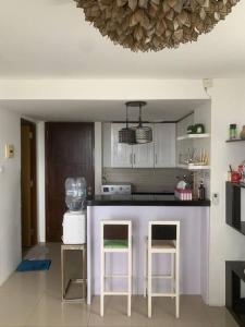cocina con encimera púrpura y 2 taburetes en 2BR VIVO Apartement by MJP, en Yogyakarta