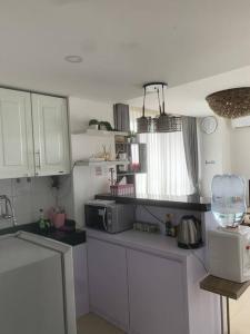 Una cocina con gabinetes blancos y un microondas. en 2BR VIVO Apartement by MJP, en Yogyakarta