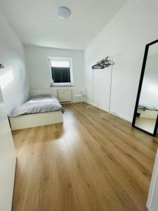 Habitación blanca con cama y espejo en Ferienwohnung in Herscheid, en Herscheid