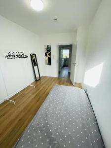 a white room with a rug on a wooden floor at Ferienwohnung in Herscheid in Herscheid