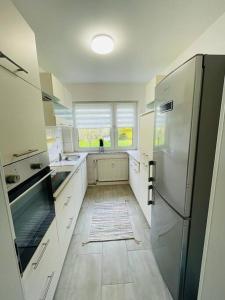 eine Küche mit weißen Schränken und einem Kühlschrank in der Unterkunft Ferienwohnung in Herscheid in Herscheid