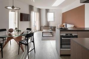 cocina y sala de estar con mesa y comedor en Portopiccolo Apartments - Appartamento Perla nel borgo, en Sistiana