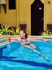 ヒッカドゥワにあるドリフターズ ホテル ＆ ビーチ レストランの女の子のプールでのドリンク