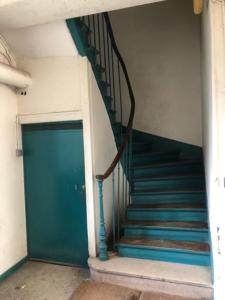 a stairway with a blue door and a blue staircase at Chat rose in Charenton-le-Pont