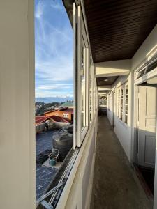 an empty corridor of a building with a window at Hideout Backpackers Hostel in Darjeeling