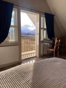 Schlafzimmer mit einem Bett und Blick auf einen Balkon in der Unterkunft Efri-Rauðilækur in Hörgársveit in Akureyri