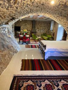 1 dormitorio con 1 cama en una pared de piedra en Αρχοντικό Γκιντώνη en Levídhion
