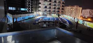a view of a pool in a city at night at Studio Apartment in Ajman 