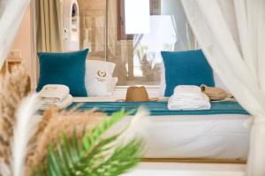 una camera da letto con un letto con cuscini e asciugamani blu di Alia Luxury Beachfront Suites and SPA a Haraki