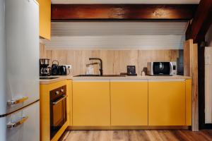 a kitchen with yellow cabinets and a microwave at Gîte Tribü in Eaux-Bonnes