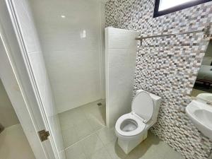 La salle de bains est pourvue de toilettes et d'un lavabo. dans l'établissement The Gun Hotel 8, à Surin