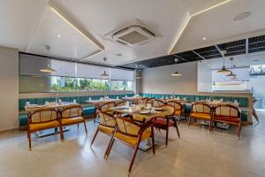 una sala da pranzo con tavoli e sedie in legno di Eminent Suites and Apartments a Hyderabad