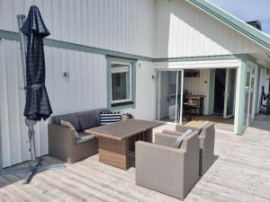 un patio con sofá, mesa y sombrilla en Studio Snäckeberg, en Åsa