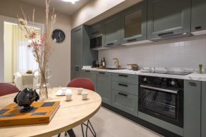 a kitchen with green cabinets and a wooden table at Dimora Màufra in Locorotondo