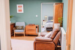 a living room with a leather chair and a bed at Little Lodge on the Yorkshire Wolds in York