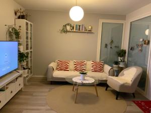 un soggiorno con divano e TV di Private room in the shared detached house. a Vantaa