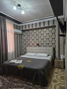 a bedroom with a bed with two towels on it at Lux in Türkistan