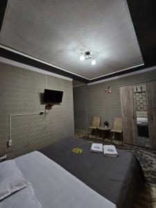 um quarto com uma cama com duas toalhas em Lux em Türkistan