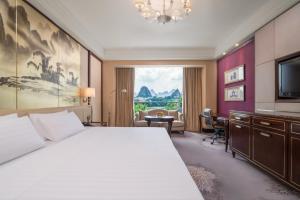 una camera con letto, scrivania e TV di Shangri-La Guilin a Guilin