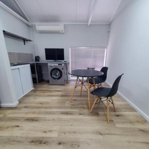 ein Zimmer mit Tisch und Stühlen und eine Küche in der Unterkunft Kupenda Africa in Montagu