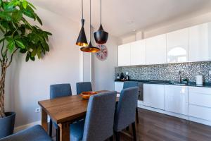 cocina y comedor con mesa de madera y sillas en Noa Apartment, en Madrid