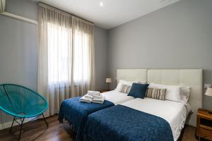 a bedroom with a bed and a chair and a window at Noa Apartment in Madrid