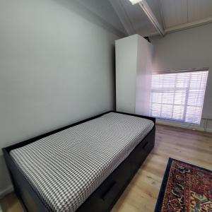 ein Schlafzimmer mit einem Bett in der Zimmerecke in der Unterkunft Kupenda Africa in Montagu