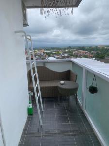 a balcony with a bench and a ladder and a table at 2BR VIVO Apartement by MJP in Yogyakarta