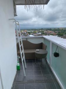 Un balcón con un banco, una escalera y una mesa. en 2BR VIVO Apartement by MJP, en Yogyakarta 4 fotos más