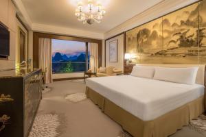 a bedroom with a large bed and a large window at Shangri-La Guilin in Guilin