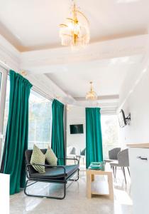 a living room with green curtains and a chandelier at EN 6 #Studio City Heart in Thessaloniki