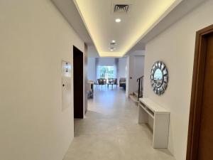 a hallway with white walls and a mirror on the wall at Nad Al Sheba 3 - 5BR Villa - Allsopp&Allsopp in Dubai