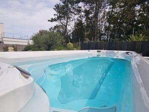 a swimming pool in a backyard with a blue at Villa d'exception, 5 chambres, 20m plage, spa. in Bénerville-sur-Mer
