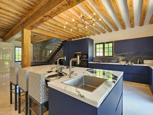 a kitchen with a sink and a counter with chairs at Villa d'exception, 5 chambres, 20m plage, spa. in Bénerville-sur-Mer
