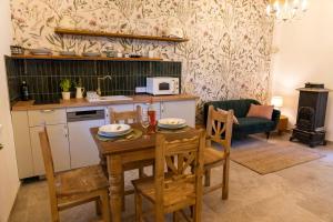 a kitchen and living room with a table and chairs at Chillinn Rosé Cottage Eger in Eger
