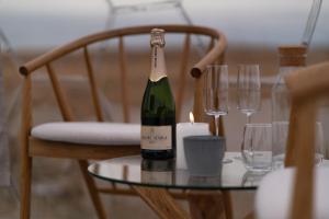 a bottle of wine sitting on a table with glasses at Aurora Igloo South in Hella