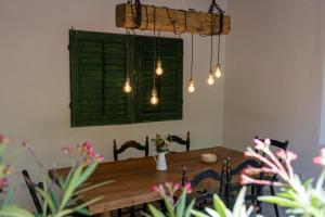 una mesa de comedor con una ventana verde y luces en EgerCottages - Rosé Cottage en Eger