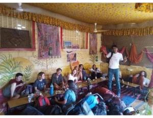 Un homme debout dans une pièce avec un groupe de personnes dans l'établissement Hotel Nutella Jaisalmer, Jaisalmer, à Jaisalmer