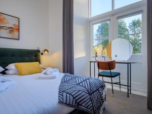 Un dormitorio con una cama, un escritorio y una silla. en The Margaret Suite Stone Cross Mansion, en Ulverston