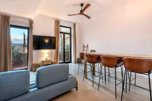 a living room with a bar and some chairs at La Guarida Suites in Barcelona