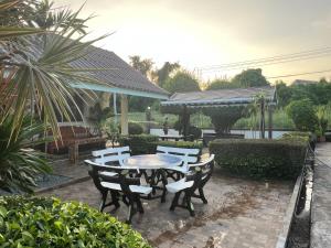a patio with a table and chairs in a yard at Suanpai Resort Sattahip in Ban Tao Than