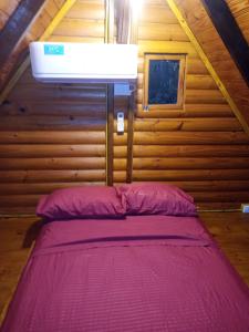 een slaapkamer met een bed in een houten hut bij Cabañas Misioneras in San Ignacio
