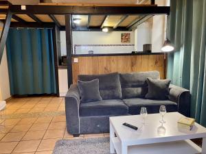ein Wohnzimmer mit einem Sofa und einem Tisch in der Unterkunft Appartement Le Cadet Roussel Auxerre Les Quais in Auxerre