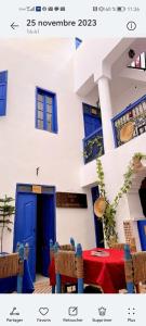 una casa con una puerta azul y una mesa con sillas en RIAD DAR LFONOUN, en Marrakech
