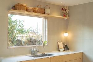 a kitchen with a sink and a window at Aewol Gilro in Jeju