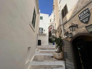 a narrow alley with a building and a sign on a building at La Rosa D Ernesto WiFi free 3 sleeping places in Ostuni